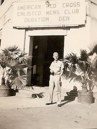 Marshall Windmiller standing outside of the American Red Cross Enlisted Men's Club Duration Den in New Delhi.